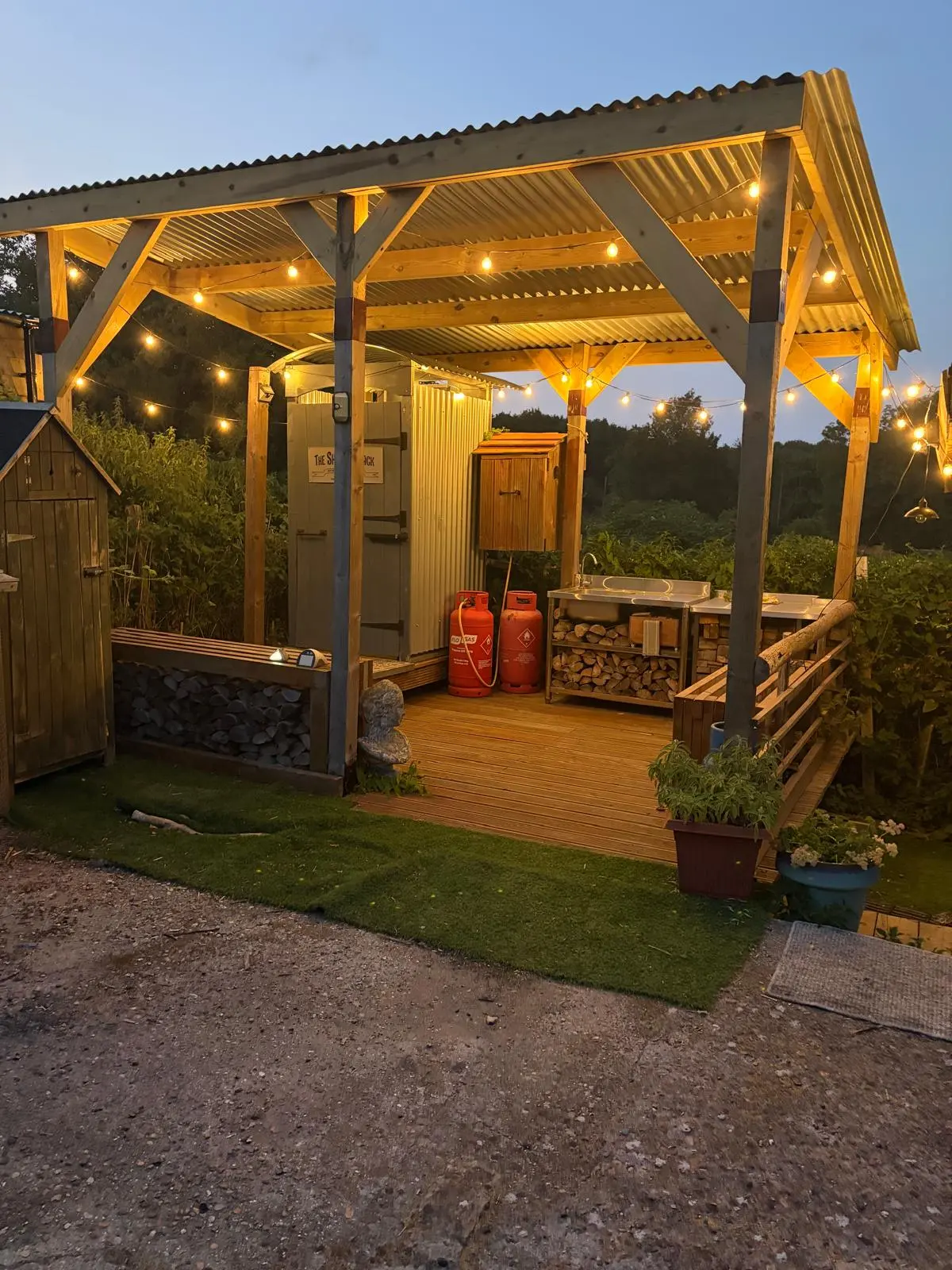 The Shower Shack on the deck at dusk, with fairy lights
